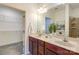 Bathroom with a double sink vanity, large mirror, and walk-in closet at 1000 E Woodlawn Rd # 110, Charlotte, NC 28209