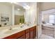 Bathroom featuring a double sink vanity and access to the bedroom and walk-in shower at 1000 E Woodlawn Rd # 110, Charlotte, NC 28209