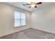 Bedroom featuring neutral carpet, a ceiling fan, and a large window at 1000 E Woodlawn Rd # 110, Charlotte, NC 28209