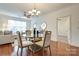 Modern dining area with a glass-top table, hardwood floors, and views into the living room at 1000 E Woodlawn Rd # 110, Charlotte, NC 28209