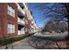 Well-maintained brick apartment complex showing the winding drive and ample parking spaces at 1000 E Woodlawn Rd # 110, Charlotte, NC 28209