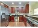 Spacious kitchen featuring stainless appliances, granite counters, and custom cherry wood cabinets at 1000 E Woodlawn Rd # 110, Charlotte, NC 28209