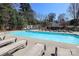 Refreshing community swimming pool surrounded by lounge chairs and lush greenery at 1000 E Woodlawn Rd # 110, Charlotte, NC 28209