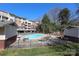 Community pool surrounded by lounge chairs, secured with a fence, and apartment building in the background at 1000 E Woodlawn Rd # 110, Charlotte, NC 28209