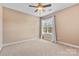 Neutral bedroom showcasing a ceiling fan and a window with curtains at 1016 Filly Dr, Indian Trail, NC 28079