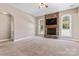 Comfortable living room with a striking stone fireplace, large windows, and neutral carpet at 1016 Filly Dr, Indian Trail, NC 28079