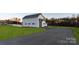 Gray detached garage with dark roof and lush yard viewed from paved driveway at 106 Isle Of Pines Rd, Mooresville, NC 28117