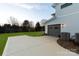 Modern gray garage exterior with custom doors, manicured lawn, and air conditioning units at 106 Isle Of Pines Rd, Mooresville, NC 28117