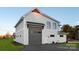 Exterior of new gray garage with metal awning, set on lush green yard, and paved drive at 106 Isle Of Pines Rd, Mooresville, NC 28117