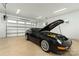 Spacious garage featuring a dark blue vintage car with its hood open, with white walls and ample lighting at 106 Isle Of Pines Rd, Mooresville, NC 28117