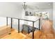 Top of stairs view of kitchen with white cabinets and stainless steel appliances at 106 Isle Of Pines Rd, Mooresville, NC 28117