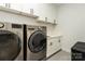 Well-organized laundry room with front load washer and dryer, white cabinetry, and plenty of storage space at 106 Isle Of Pines Rd, Mooresville, NC 28117