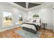 Bright main bedroom featuring a unique tray ceiling, two windows and hardwood floors at 106 Isle Of Pines Rd, Mooresville, NC 28117