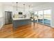 Modern kitchen featuring white cabinets, a gray island, stainless steel appliances, and wood floors at 108 Isle Of Pines Rd # 3, Mooresville, NC 28117