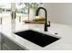 Quartz countertop with black sink and pull-down faucet sitting atop gray kitchen island at 108 Isle Of Pines Rd # 3, Mooresville, NC 28117