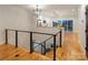 View of staircase with wood flooring leading to kitchen with stainless appliances and star-shaped chandelier at 108 Isle Of Pines Rd # 3, Mooresville, NC 28117