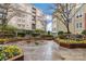 Exterior courtyard featuring stone details, manicured flowerbeds, with multi-story condo buildings in the background at 1320 Fillmore St # 419, Charlotte, NC 28203
