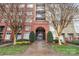 Exterior entrance with brick archway, signage indicating address, and manicured landscaping at 1320 Fillmore St # 419, Charlotte, NC 28203