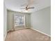 This is a small, carpeted bedroom featuring a standard window and simple finishes at 13424 Portside Ct, Charlotte, NC 28278