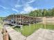 Large boat house on a lake with multiple boat slips, dock access, and clear water at 13424 Portside Ct, Charlotte, NC 28278