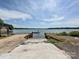 Concrete boat ramp leading into a calm lake with blue skies, providing easy water access at 13424 Portside Ct, Charlotte, NC 28278