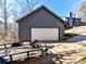 Modern garage with a large door, adjacent to a contemporary home, with a trailer parked in front at 13424 Portside Ct, Charlotte, NC 28278