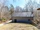 Grey siding building with one car garage and adjacent wooded yard at 13424 Portside Ct, Charlotte, NC 28278