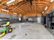 Spacious garage featuring a high ceiling with wood beams, storage cabinets, and ample workspace at 13424 Portside Ct, Charlotte, NC 28278