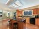 Kitchen with wood cabinets, granite island with seating, and a view of the living room with a fireplace at 13424 Portside Ct, Charlotte, NC 28278