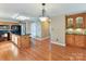 Open kitchen with a granite island, black appliances, wooden cabinetry, and modern lighting at 13424 Portside Ct, Charlotte, NC 28278
