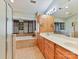 Bright main bathroom with a double vanity, tile floors, and an elegant soaking tub with window views at 13424 Portside Ct, Charlotte, NC 28278