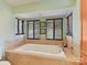 Close up of the soaking tub in the main bath, framed by windows and tiled surround at 13424 Portside Ct, Charlotte, NC 28278