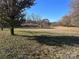 Spacious grassy backyard with mature trees, offering plenty of space for outdoor activities at 1415 S Morgan St, Shelby, NC 28152
