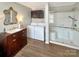 Updated bathroom with a vanity, toilet, and modern glass-enclosed shower, featuring a washer and dryer at 1465 Earl St, Hickory, NC 28602