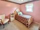 Pink bedroom with a single bed, side table, chair, and natural light from a window at 1465 Earl St, Hickory, NC 28602