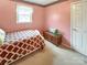 Pink bedroom features a cozy bed and a wooden chest by the window, offering storage at 1465 Earl St, Hickory, NC 28602