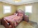 Bedroom showcasing a carved wooden bed frame, patterned bedspread, and natural light at 1465 Earl St, Hickory, NC 28602