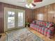 Inviting living room featuring wood paneling, ceiling fan and a door leading to the backyard at 1465 Earl St, Hickory, NC 28602