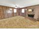 Spacious living room with fireplace, brick surround, wood paneling and a ceiling fan at 1465 Earl St, Hickory, NC 28602