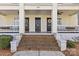 Close-up of a welcoming entrance with three doors, brick steps, and decorative wreaths at 1517 Cleveland Ave # D, Charlotte, NC 28203