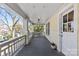 Inviting front porch with white columns, gray floors, and a front door at 1517 Cleveland Ave # D, Charlotte, NC 28203