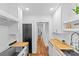 Well-lit kitchen offers wood countertops, white cabinets, stainless steel appliances, and view to hallway at 1517 Cleveland Ave # D, Charlotte, NC 28203
