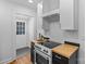 Cozy kitchen with stainless steel oven, wood countertops, white cabinets, and view to white exterior door at 1517 Cleveland Ave # D, Charlotte, NC 28203