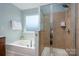 Modern bathroom featuring a soaking tub and separate glass-enclosed shower with tiled surround at 1526 Kilburn Ln, Fort Mill, SC 29715