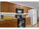 Spacious kitchen with wooden cabinets, black appliances, granite countertops, and wood-look flooring at 166 Chere Helen Dr, Mooresville, NC 28115