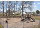 Neighborhood playground includes swings and slides surrounded by trees, houses and grass at 166 Chere Helen Dr, Mooresville, NC 28115