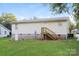 Backyard view showcasing a white siding home with a small deck, a lawn, and a neighboring property at 19 Church St, York, SC 29745