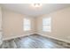 Bedroom featuring neutral walls, two windows, and gray wood-look floors at 19 Church St, York, SC 29745