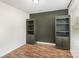 Bedroom with hardwood floors, olive colored accent wall, two dark green bookshelves and natural light at 205 Athens Dr # 31, Salisbury, NC 28147