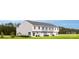 Rear exterior view of townhomes with green grass and young trees on a bright sunny day at 2061 Stephens Farm Dr, China Grove, NC 28023